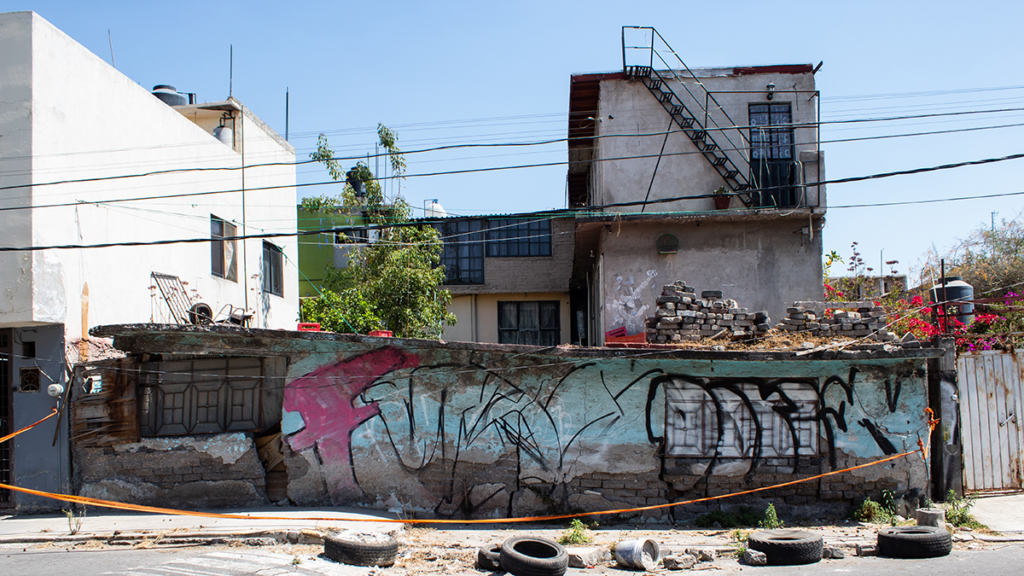 Foto de una casa que es más baja por un lado que por otro. La casa está cubierta de graffitis.