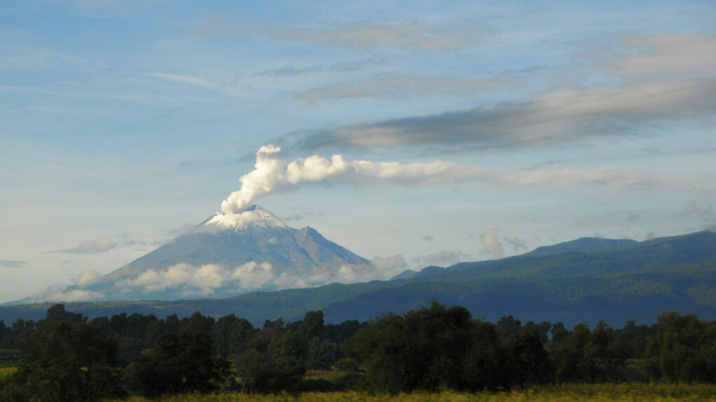 Popocatépetl erupts with wisps of volcanic gas, as seen from Puebla, Mexico.