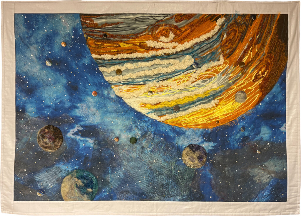 Textile art using yarn, buttons, paint, and fabric depicts Jupiter and its moons.