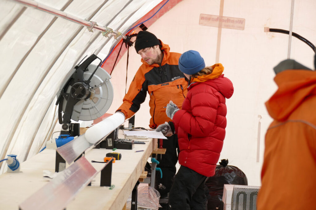 Scientists study an ice core in a tent in Antarctica.