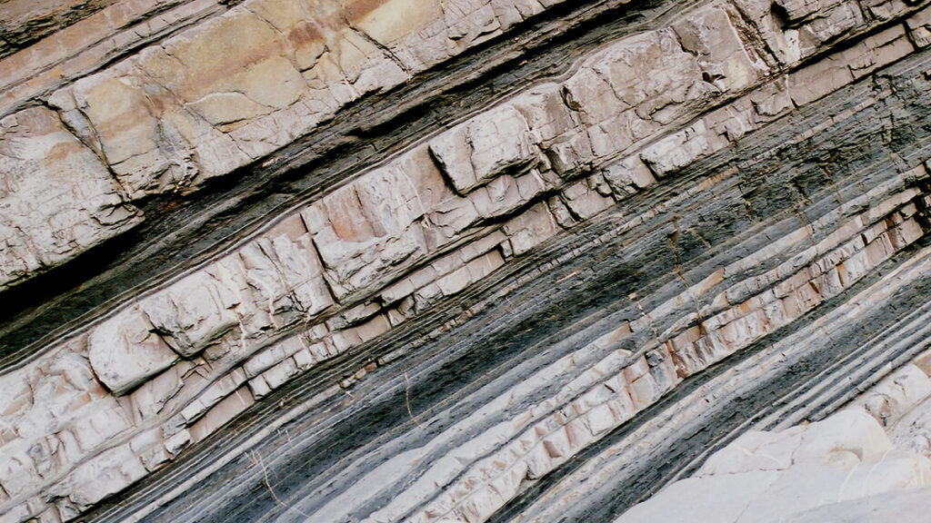 Stacked sedimentary rock layers of different thicknesses make up a turbidite bed.