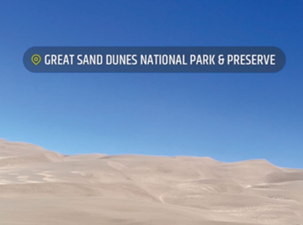 A photo of sand dunes under a blue sky is annotated with a Snapchat sticker identifying the location: “Great Sand Dunes National Park & Preserve.”