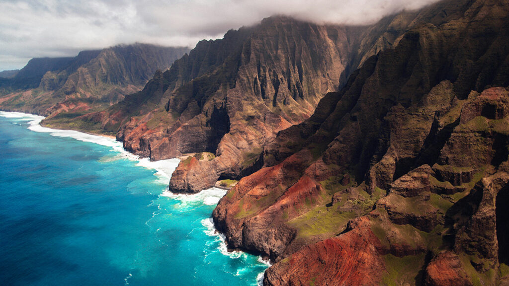 Clouds linger above the lush, mountainous landscape of Kauai’s Nā Pali Coast State Park.