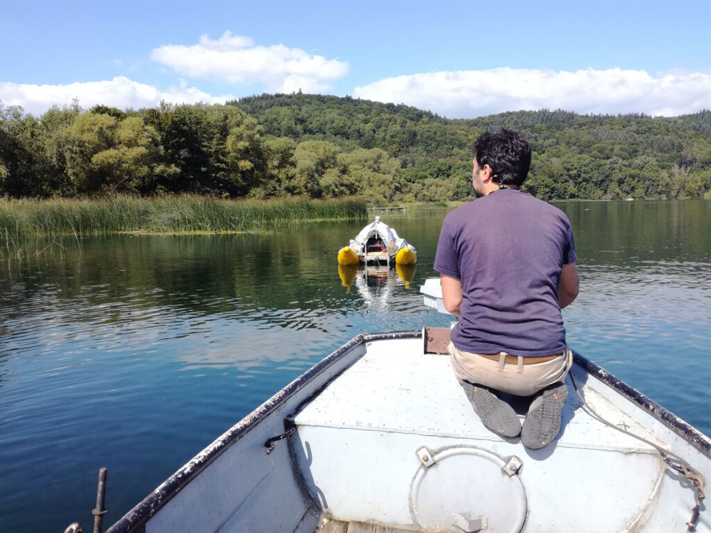 Teammitglied Zakaria Ghazoui prüft eine Hydrofoneinheit, die unter einem Floß im Laacher See angebracht ist.