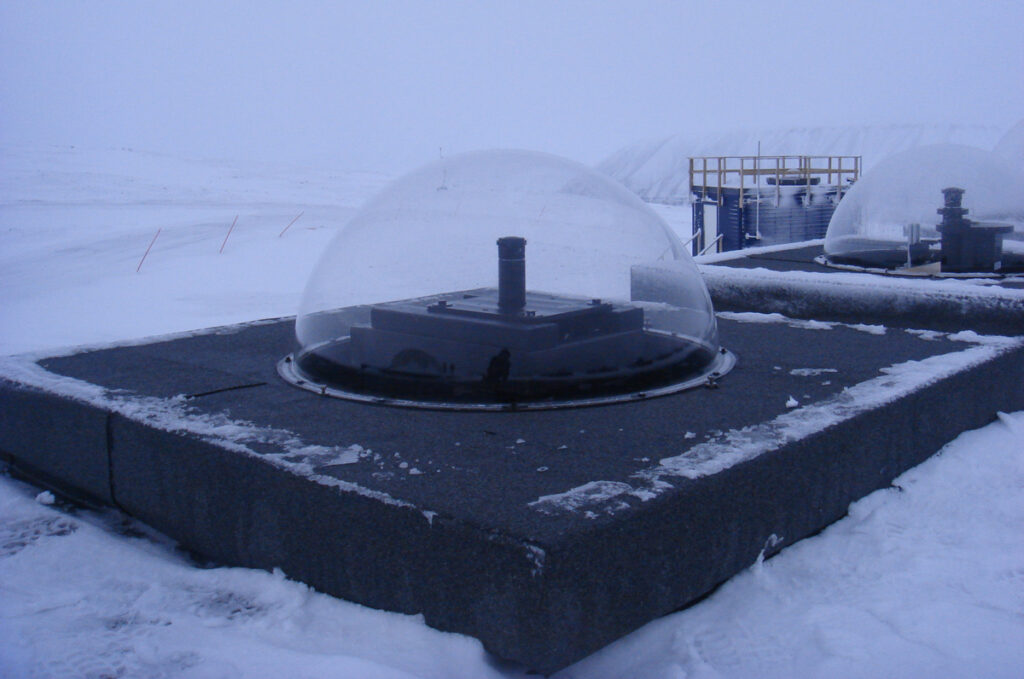 A camera with a glass dome over it located in a snowy landscape