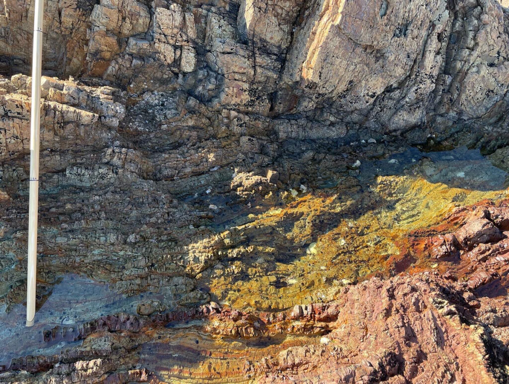 An exposed cliff with layers of colorful rock