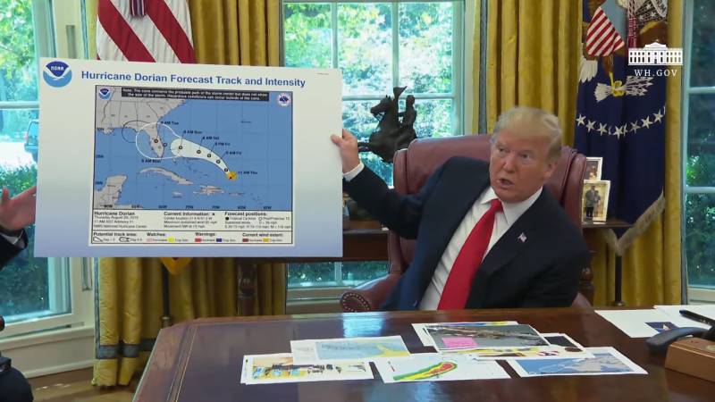 President Trump holds a hurricane forecast map with an altered path drawn in permanent marker.