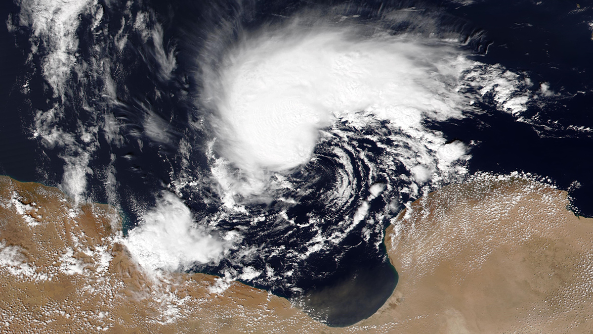 A satellite image shows the white storm clouds of a cyclone swirling off the arid coast of Libya.