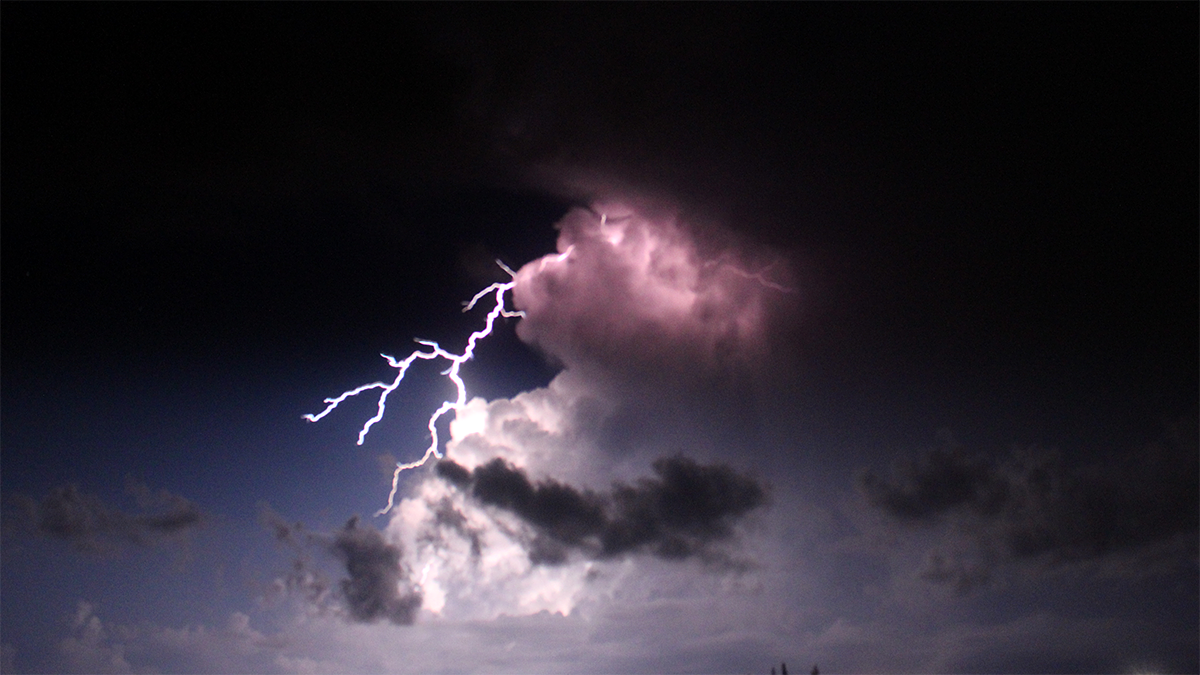 A lightning flash extending outside of a thundercloud.