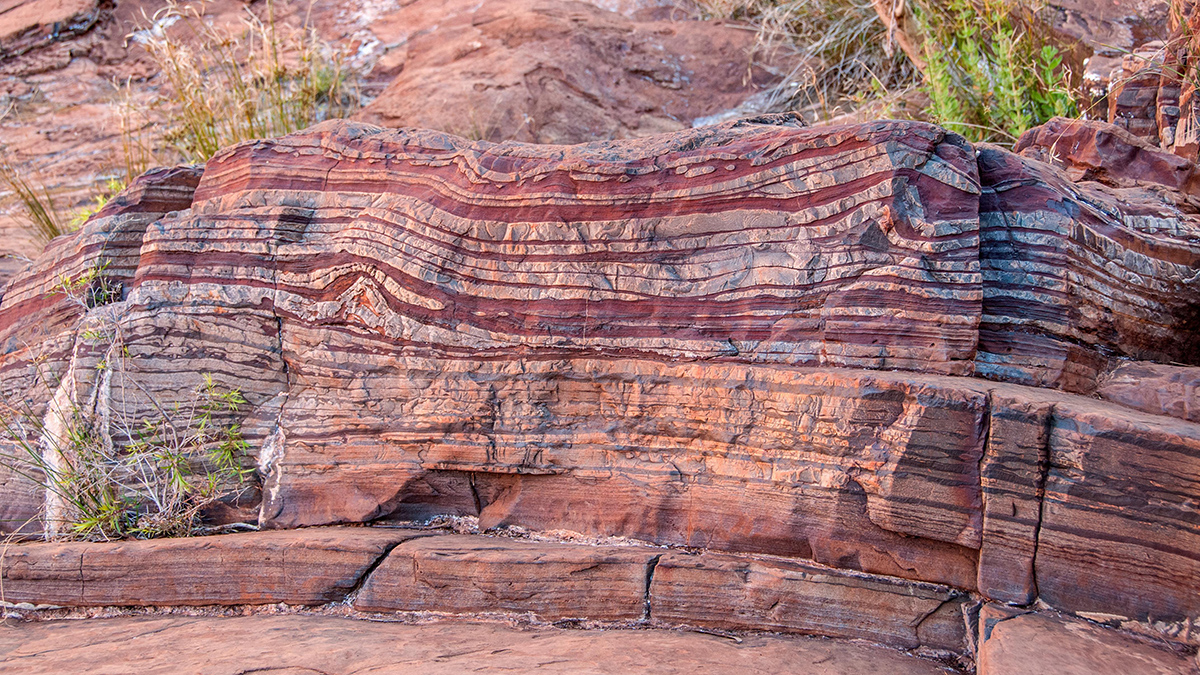 A cliff face with pink and red layers