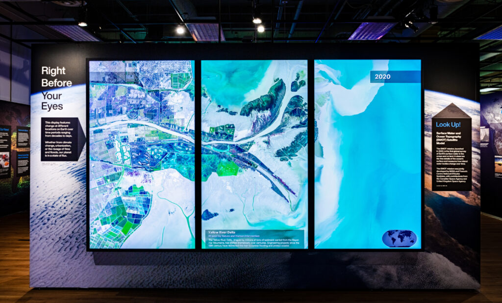 Three vertical displays showing satellite data of a coastal city