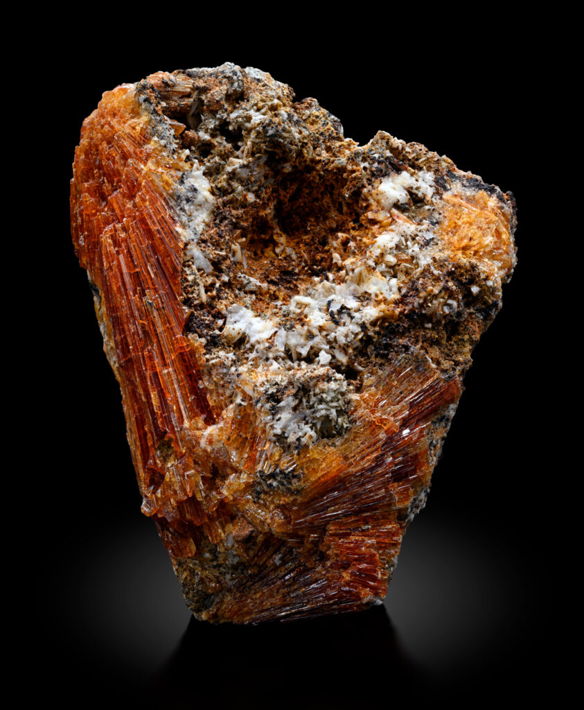 Heart-shaped orange, white, and brown mineral on a black background