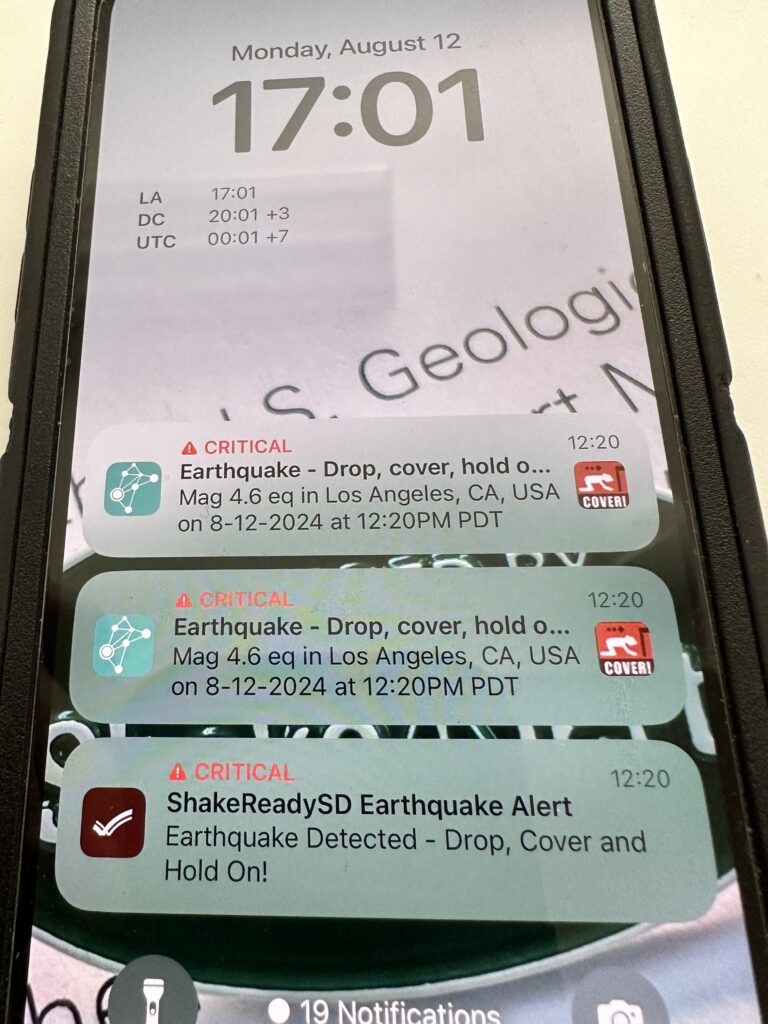 A photograph of a mobile phone screen shows three earthquake alerts.