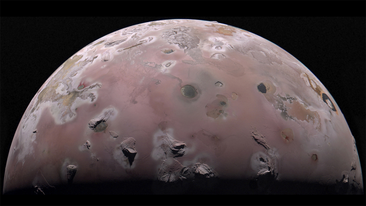 A hemisphere image of a pink-tinged volcanic world