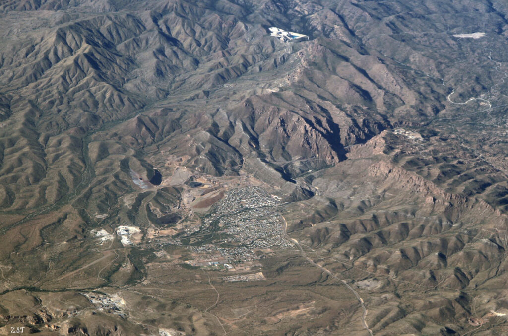 Aerial view of a town and roads next to a canyon.