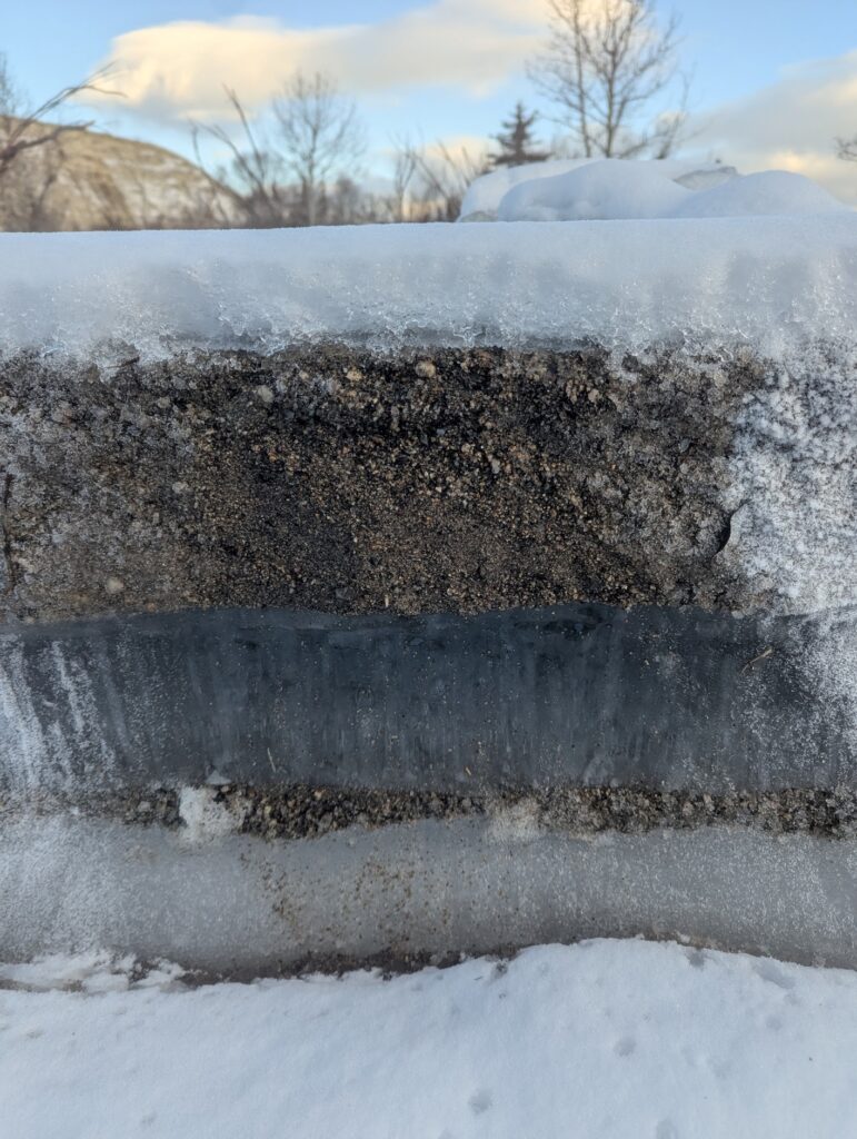 Beds of sand frozen to a 2 m x 1.5 m x 0.3 m block of ice suggest river ice frozen to the bed was plucked and plucked flipped in the Takhini River landslide tsunami.