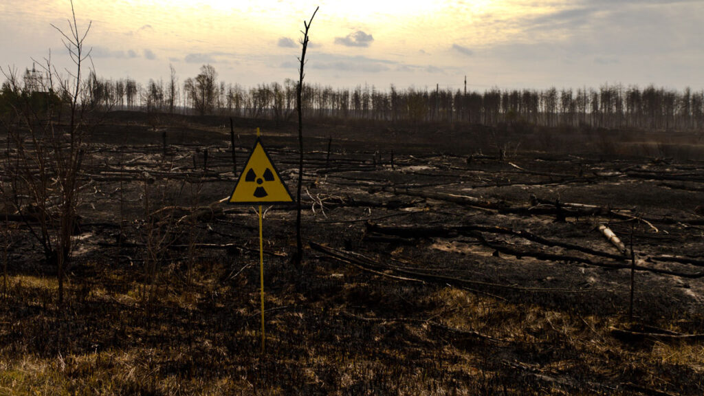 A radiation warning sign in front of a wooded area
