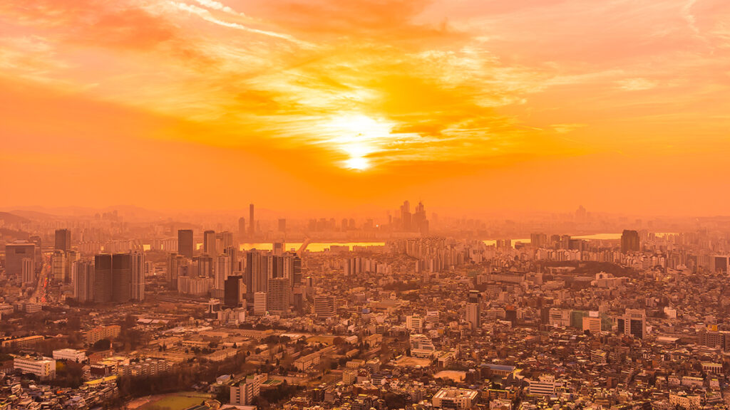 An aerial view of Seoul, South Korea, bathed in orange light at sunrise
