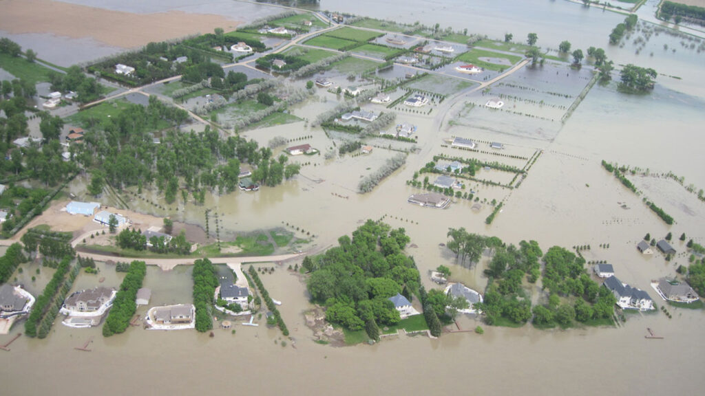 An aerial view of flooding near Bismark, N.D., showing streets, yards, and farmland all underwater.