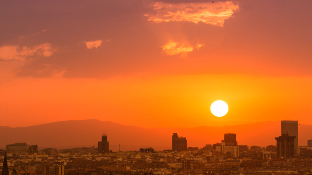 The Sun sets in an orange sky over the city of Madrid.