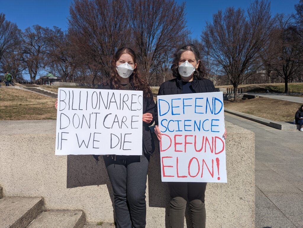 Two people holding signs with writing