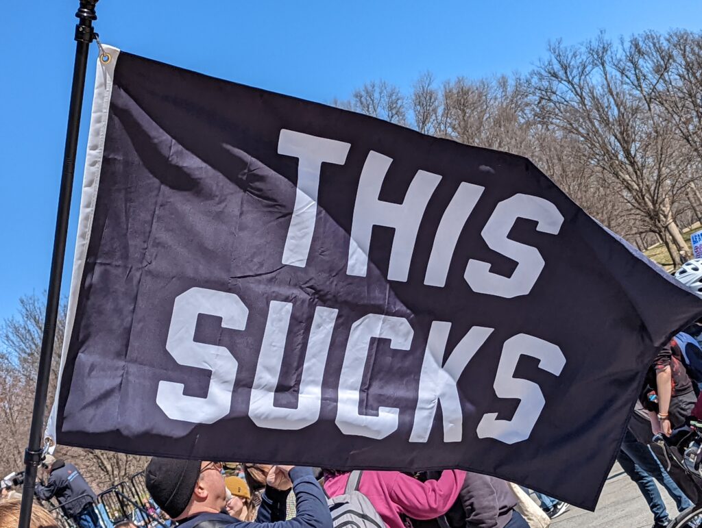 A black flag with "This Sucks" flying in the breeze