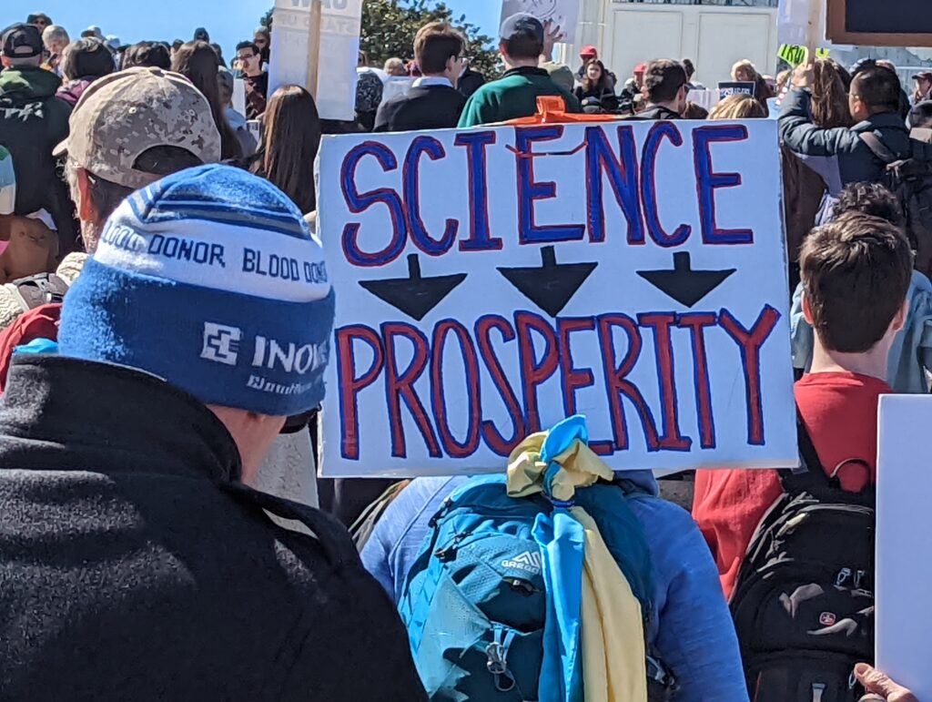 Protest sign: Science → Prosperity