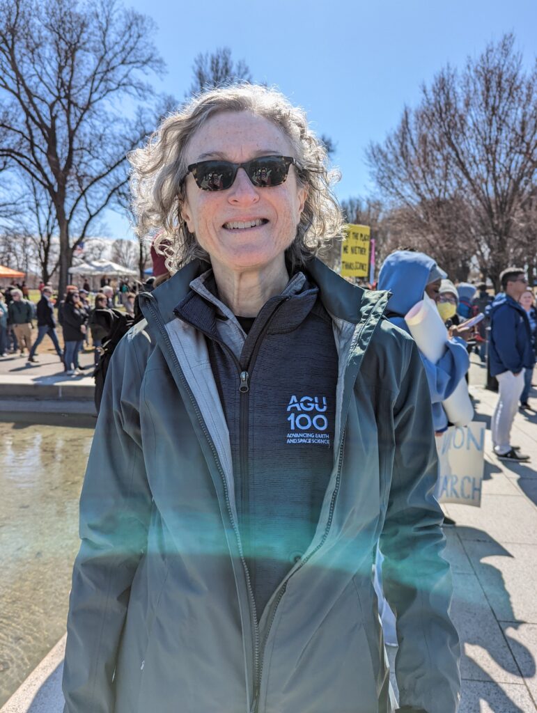 Chris McEntee smiles in a crowd on a sunny day.