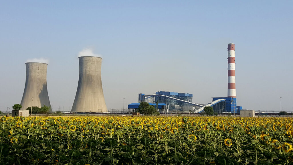 The coal-fired Rajpura Thermal Power Plant sits behind a field of sunflowers in Rajpura, Punjab, India.