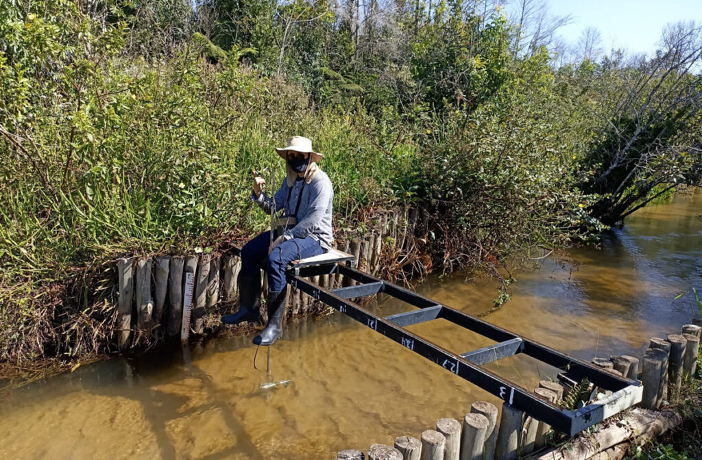A researcher measures a river’s flow.