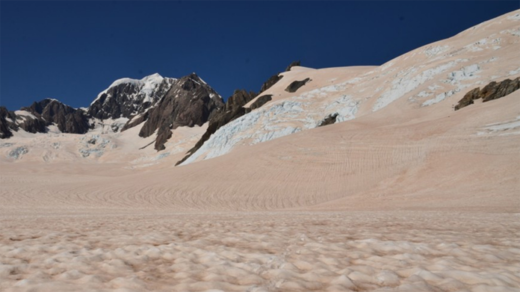 Photo of the snowy Southern Alps covered in red dust.