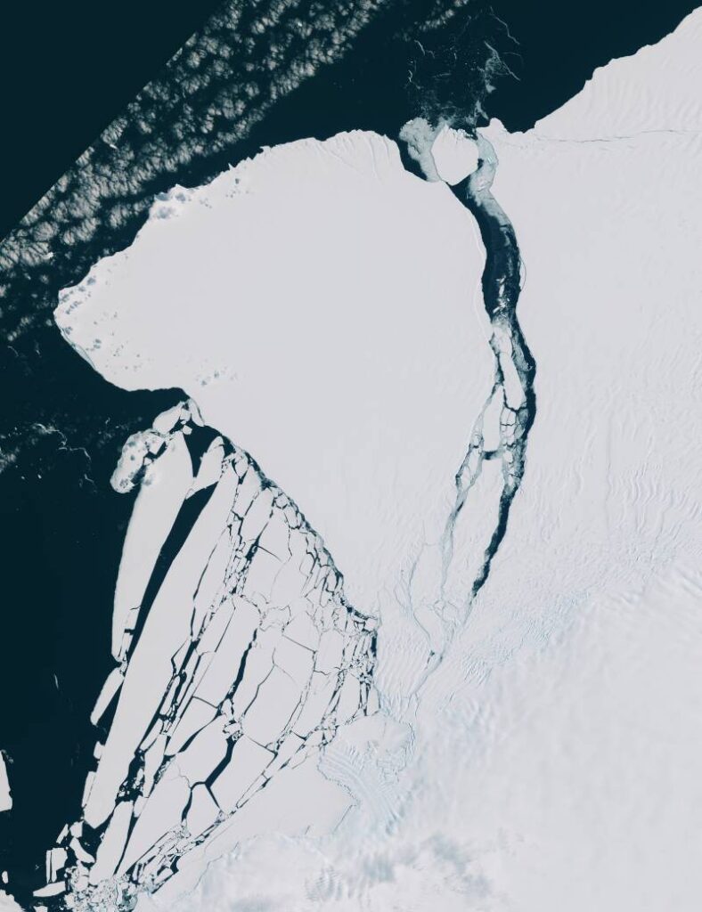 A satellite image of a large iceberg breaking off an ice shelf.