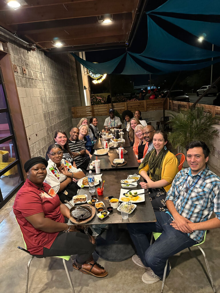 A group of 15 people sits at a restaurant table.