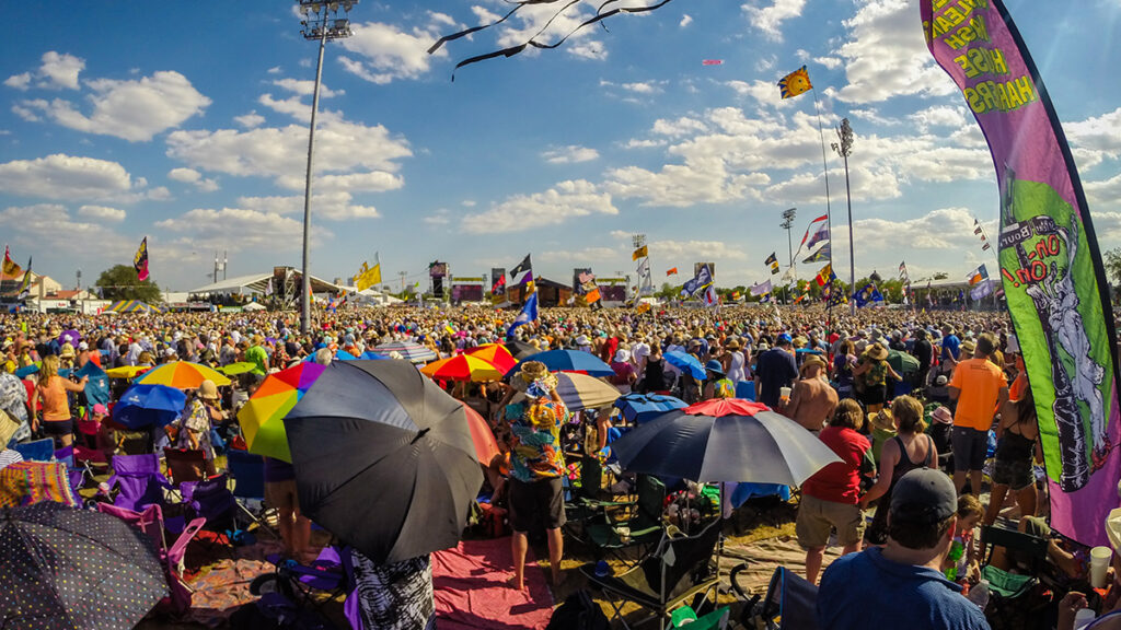 A crowd of thousands of people stand outdoors.