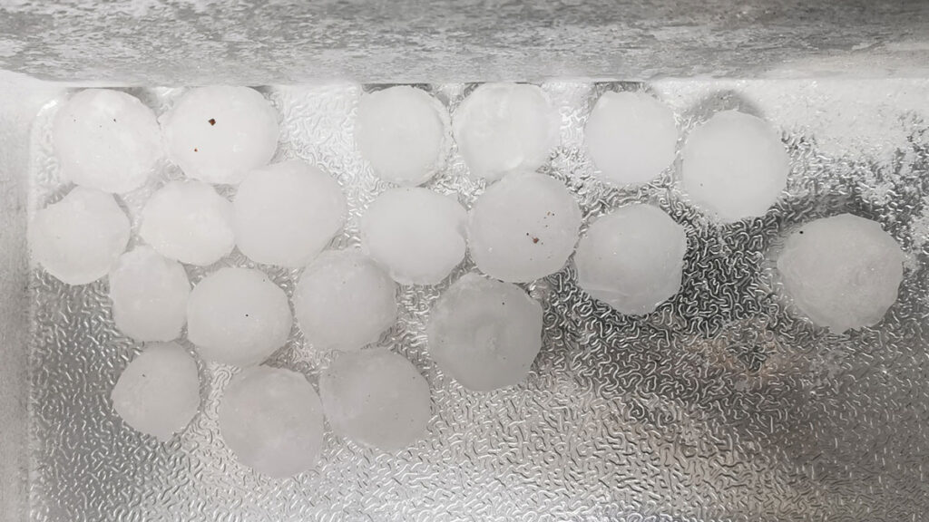 A silver cooler with 20 round hailstones