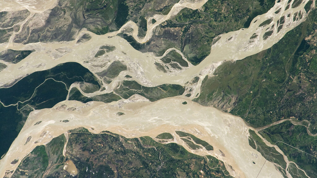 A satellite image of a braided river shows many channels branching out and reconnecting.