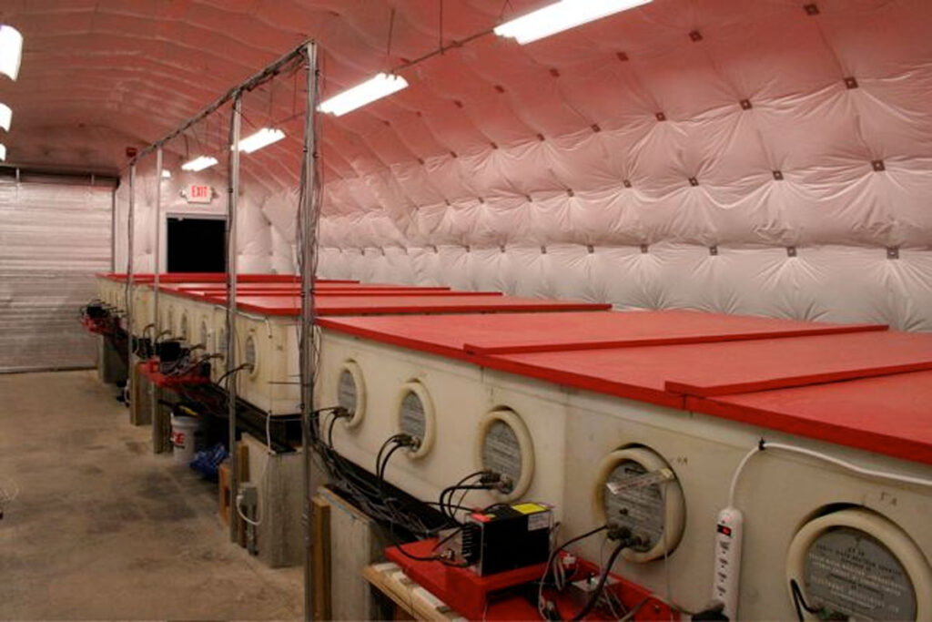 Scientific monitoring equipment sits inside a well-lit Quonset hut.