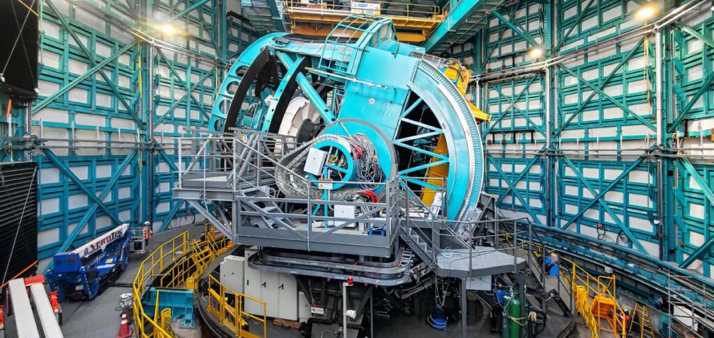 A large teal telescope inside a round structure.