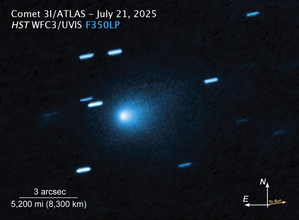 A blue-shaded image of a comet with a diffuse coma. A few star streaks are visible, as well as scaling and direction information.