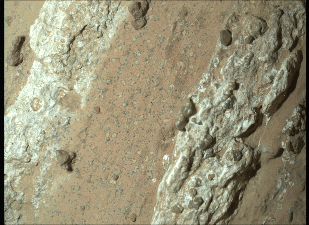 A reddish rock, flanked by two whiter rocks.