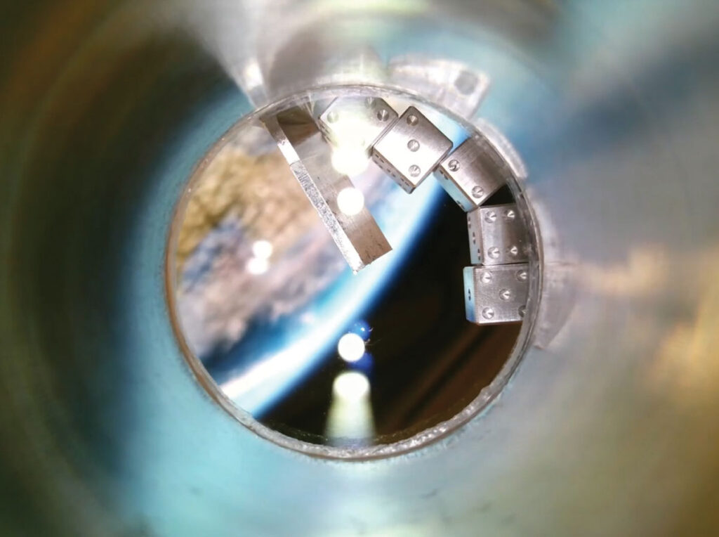 Five silver metallic dice tumble in a circular window with Earth in the background.