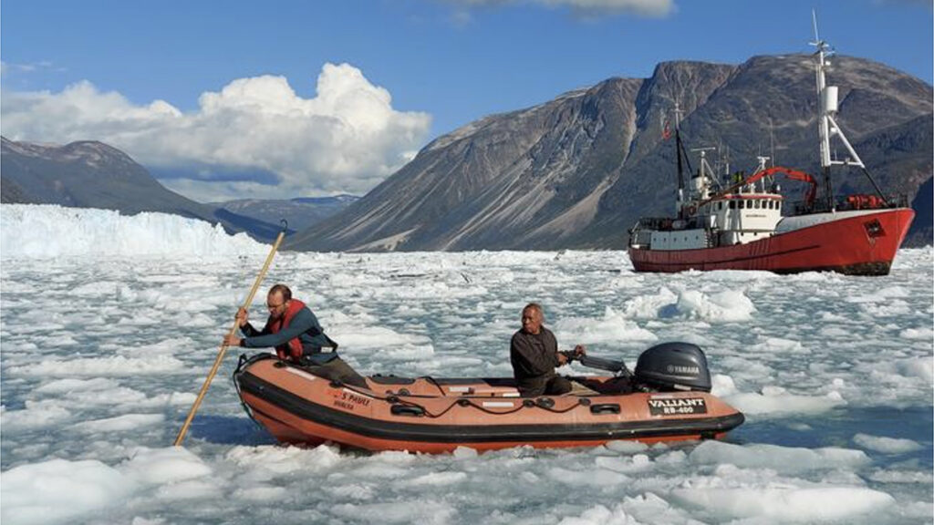 Two men in a Zodiac navigate icy waters.