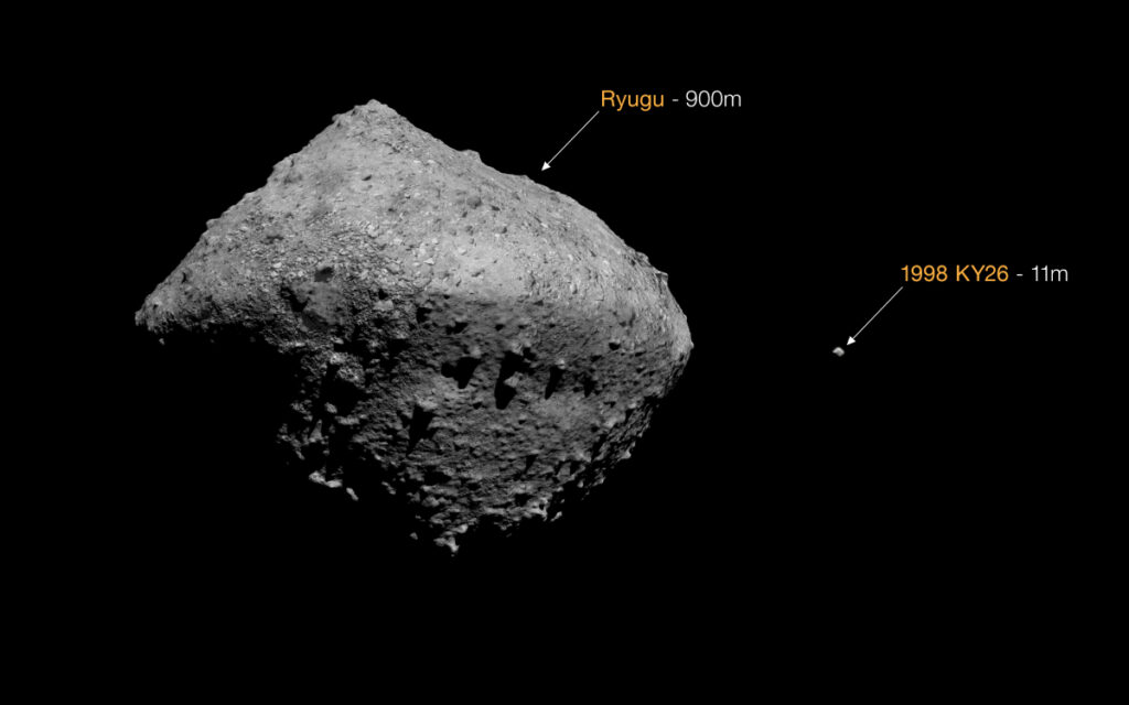 Illustration showing two diamond-shaped asteroids: one large and one very small. The large one is labeled “Ryugu–900m,” and the small one is labeled “1998 KY26–11m.”