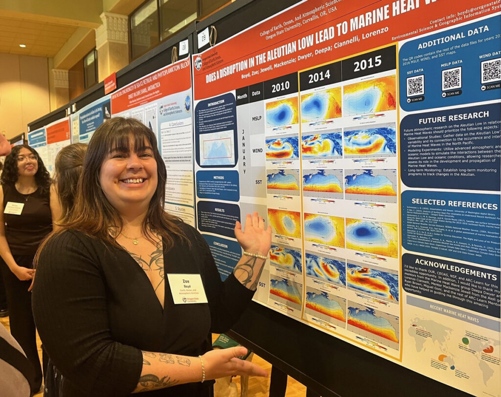 A woman stands by and displays a research poster.