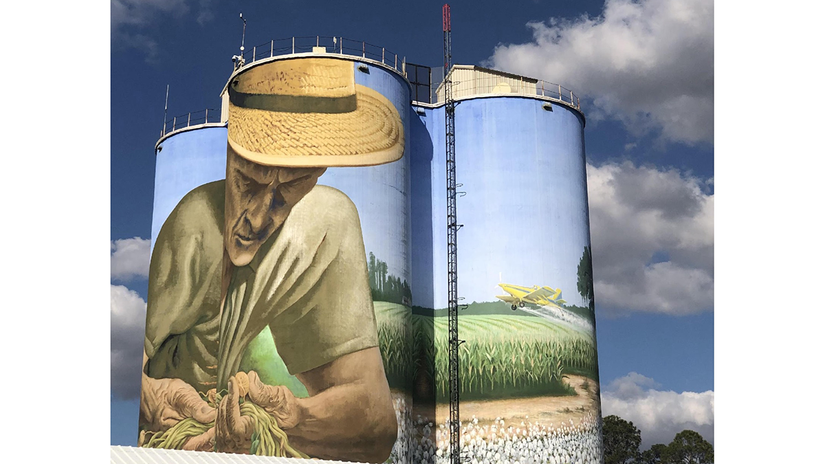 Photo of silos with a mural painted on them.