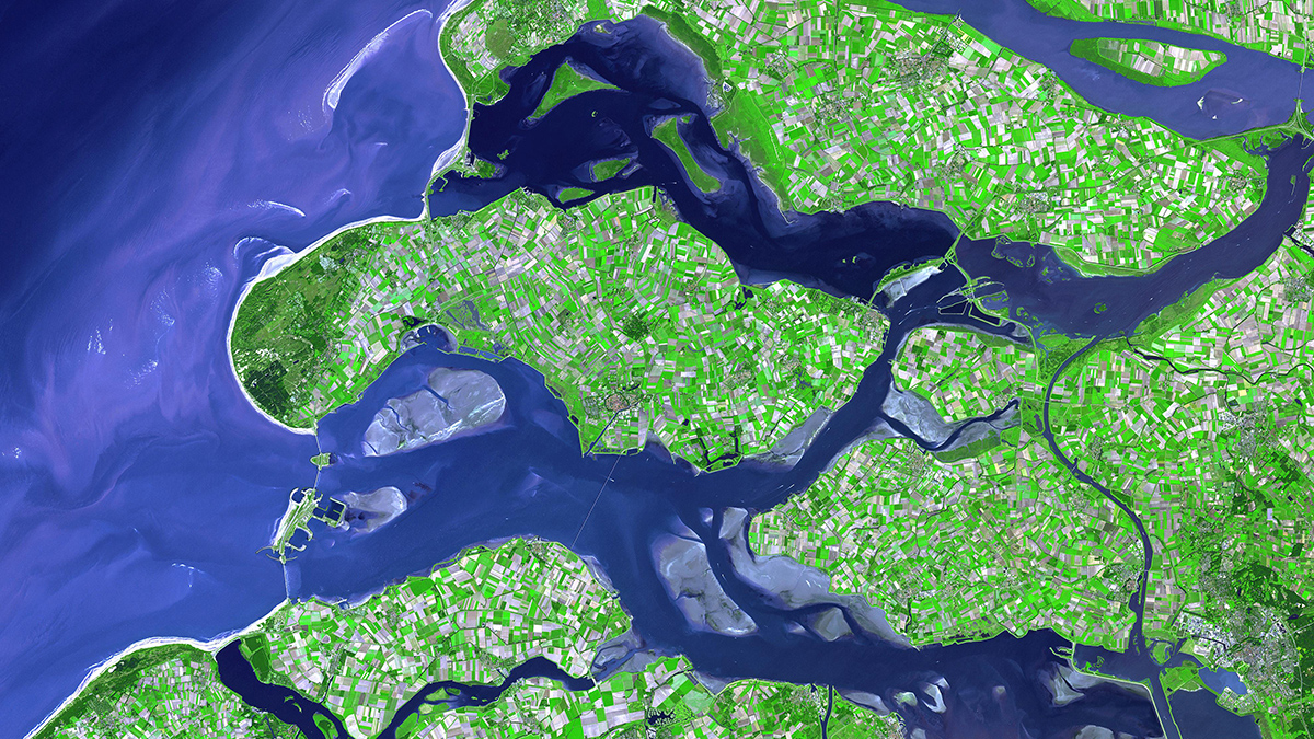 A satellite view of the southwestern coastline of the Netherlands shows a crisscross of rivers, estuaries, and canals.