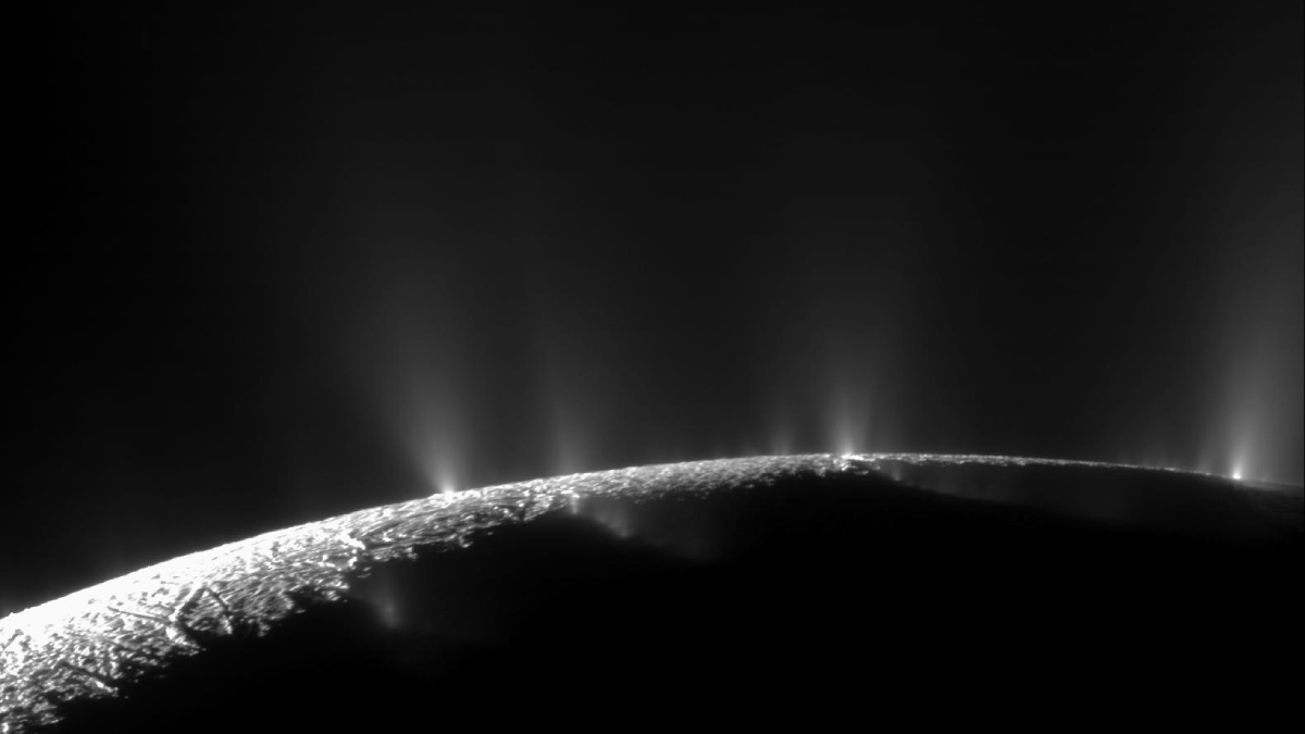 Enceladus’s horizon backlit by the Sun, highlighting several plumes of material coming from the surface.