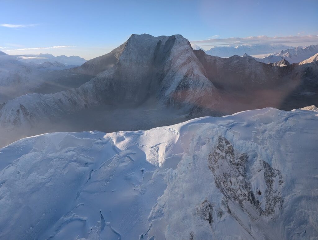 View southwest towards Mt. King George. Snow avalanche and serac collapse scars are visible on the ridge in the foreground, large rock avalanche scars on the NE face of Mt. King George are visible in the background.