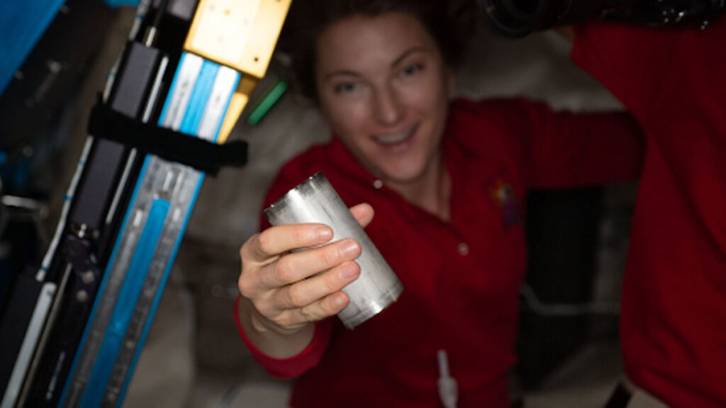 NASA astronaut Kayla Barron holds a filter used to recycle wastewater.