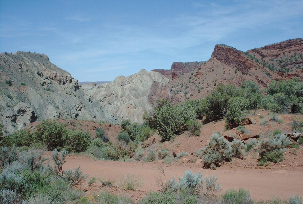 A pale gray geologic structure emerges from the rocky red landscape of Utah.